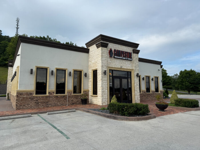 Front of Campestre Mexican Bar and Grill, a white and brick building with tall black-trimmed windows, a central entrance, and simple landscaping out front.