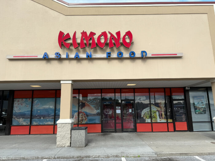 Front of Kimono Asian Food restaurant in a shopping plaza, with large red and blue signage above the entrance and mural-style window art featuring landscapes and traditional attire.