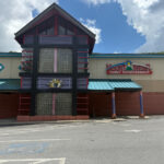 Colorful entrance to Mountaineer Bowling Lanes, a family entertainment center with a teal roof, decorative glass block tower, and bold red and blue accents.