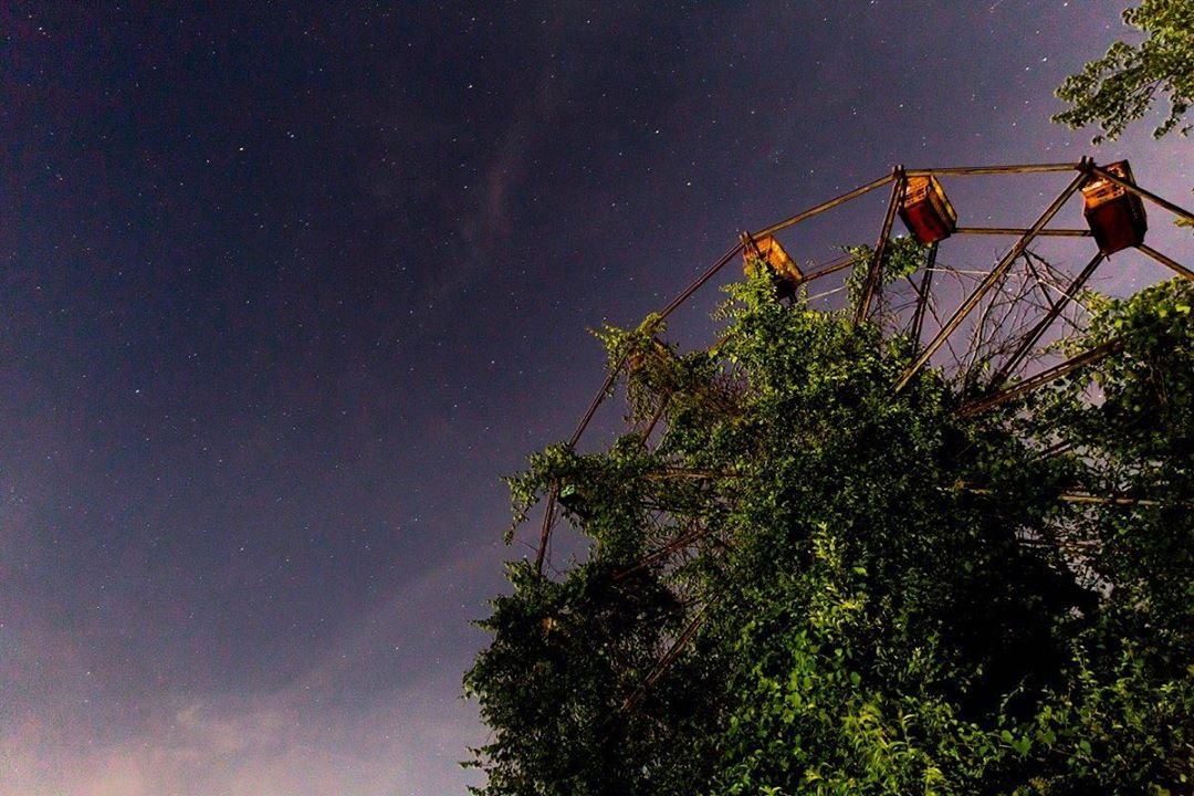 Ferris wheel at Lake Shawnee Abandoned Amusement Park silhouetted against the night sky in Mercer County, West Virginia.