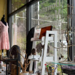 Storefront display at Downtown Merchants featuring crystals, jewelry, and a pink dress on a mannequin by the window.