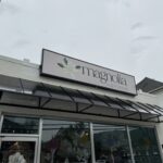 Exterior of Magnolia on Jefferson floral shop with a flower logo on the sign above the large front windows.