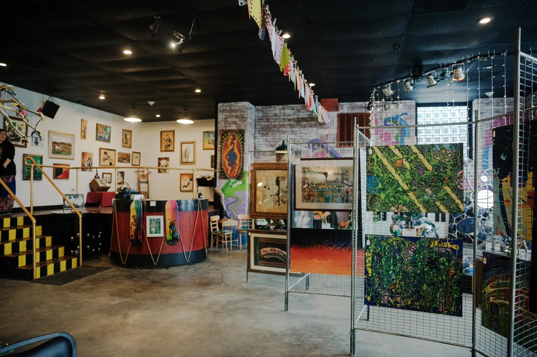 An art gallery displaying artwork of varying mediums and styles.