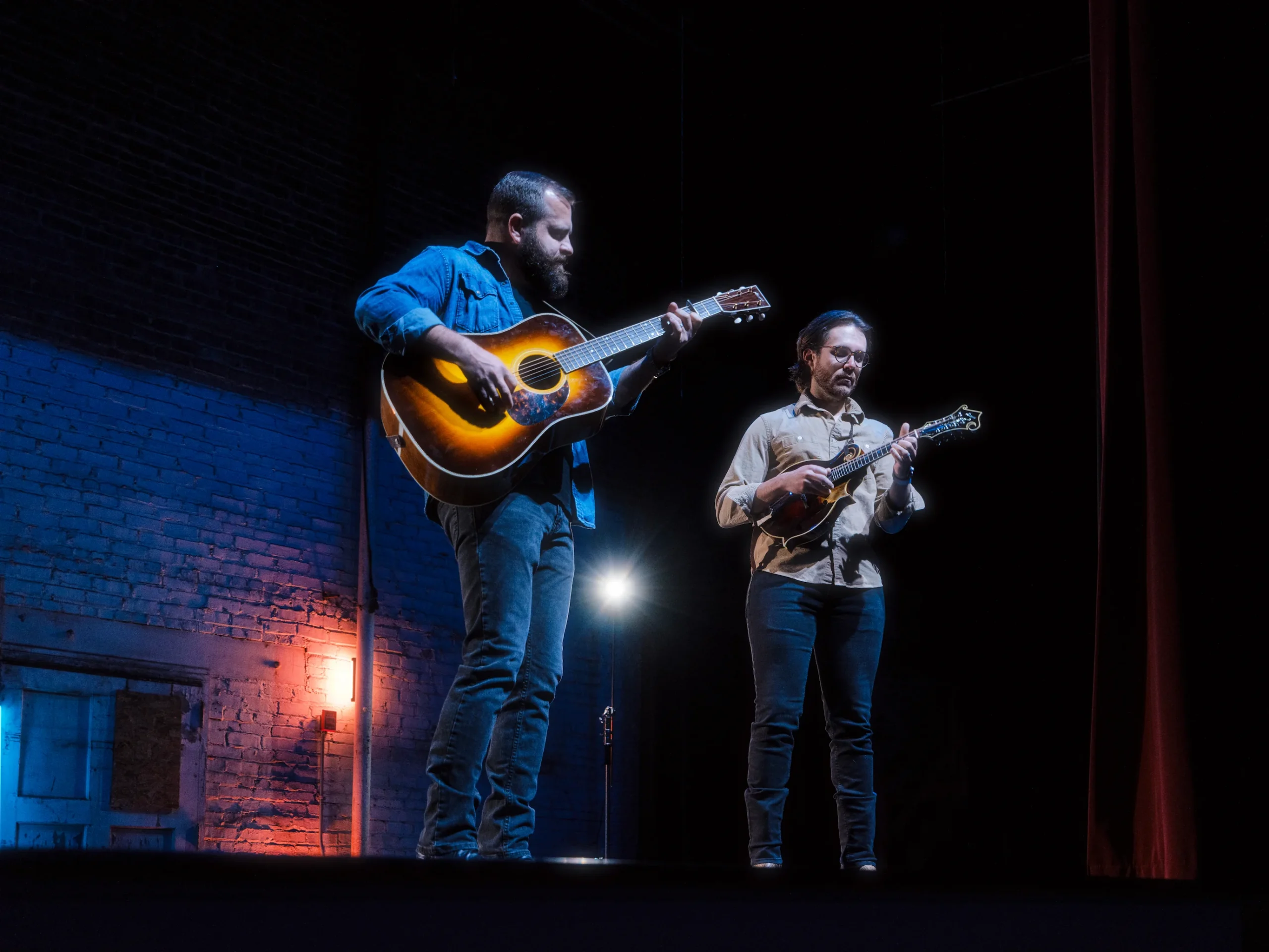Lit by stage lights at the Granada theater, two musicians play acoustic tunes—a guitar and mandolin duo turning a small stage into a big memory.