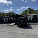 Coal Miner’s Jerky Co. storefront in Princeton, West Virginia, with a large “Free Samples” sign outside on a sunny day.