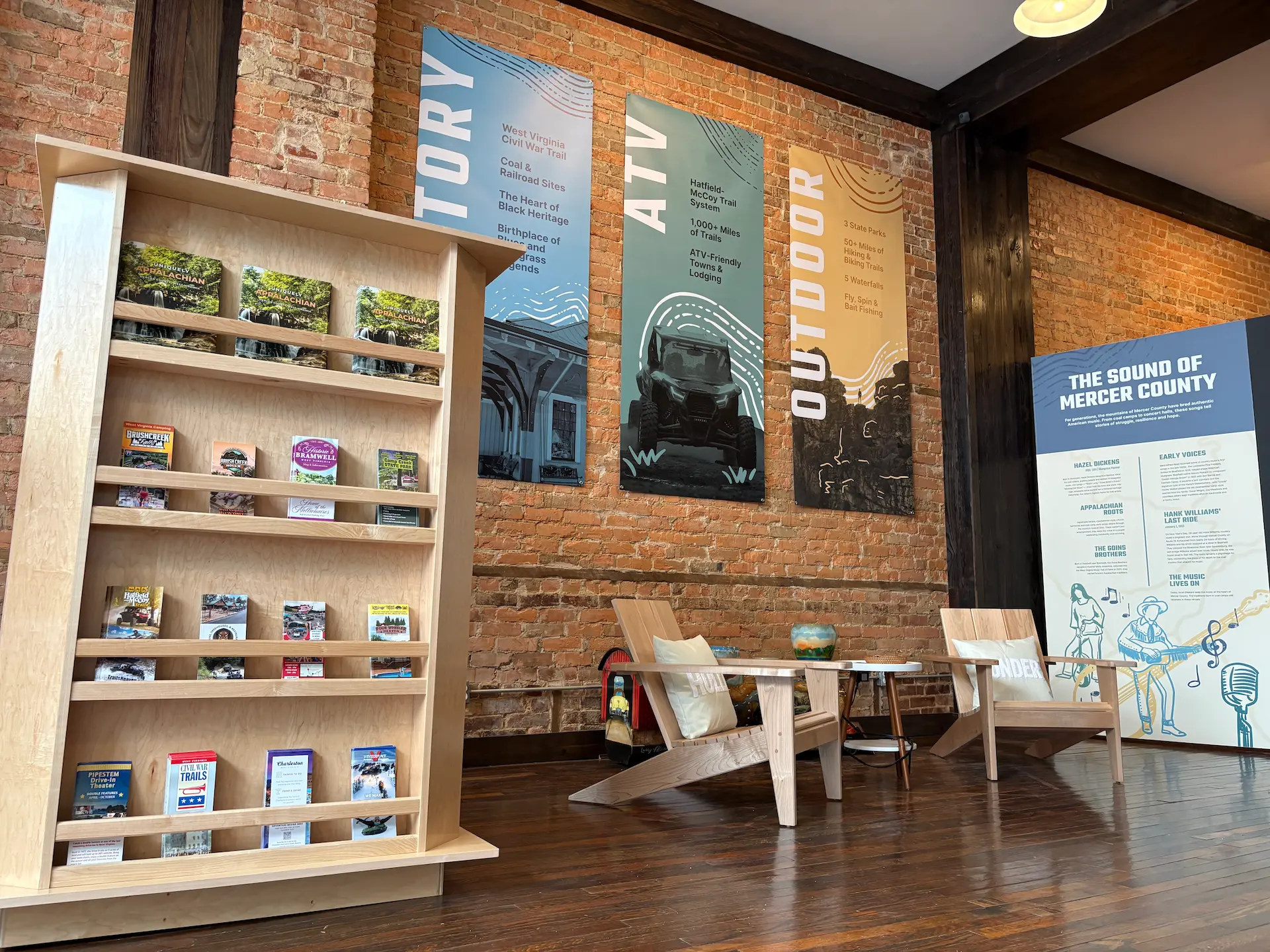 Modern visitor center interior with wooden shelving, white chairs, brick walls, and large outdoor recreation murals.